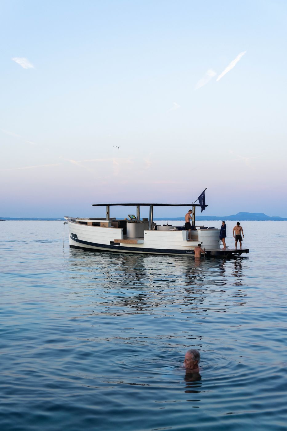 The SAMAR 50 at anchor at dusk with guests swimming